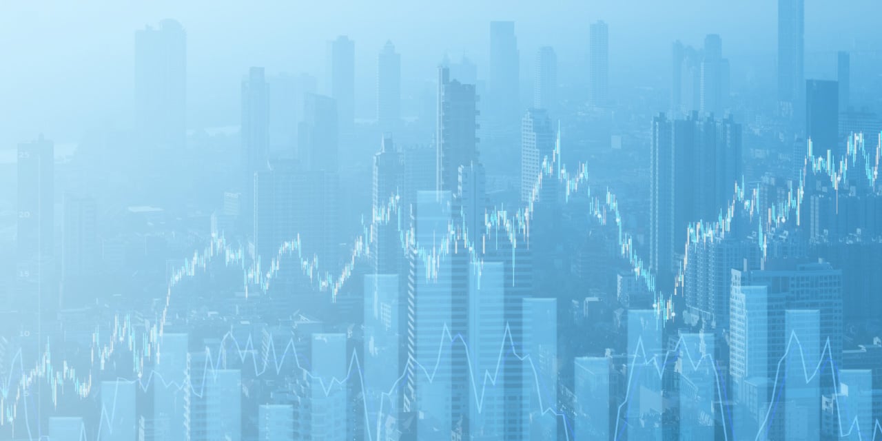 City skyline with overlaid financial graph lines indicating market trends.