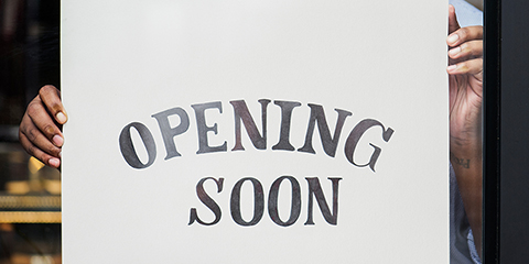DemocOfCapital_Man-Hanging-Opening-Soon-Sign-in-Store-Front_480x240.jpg